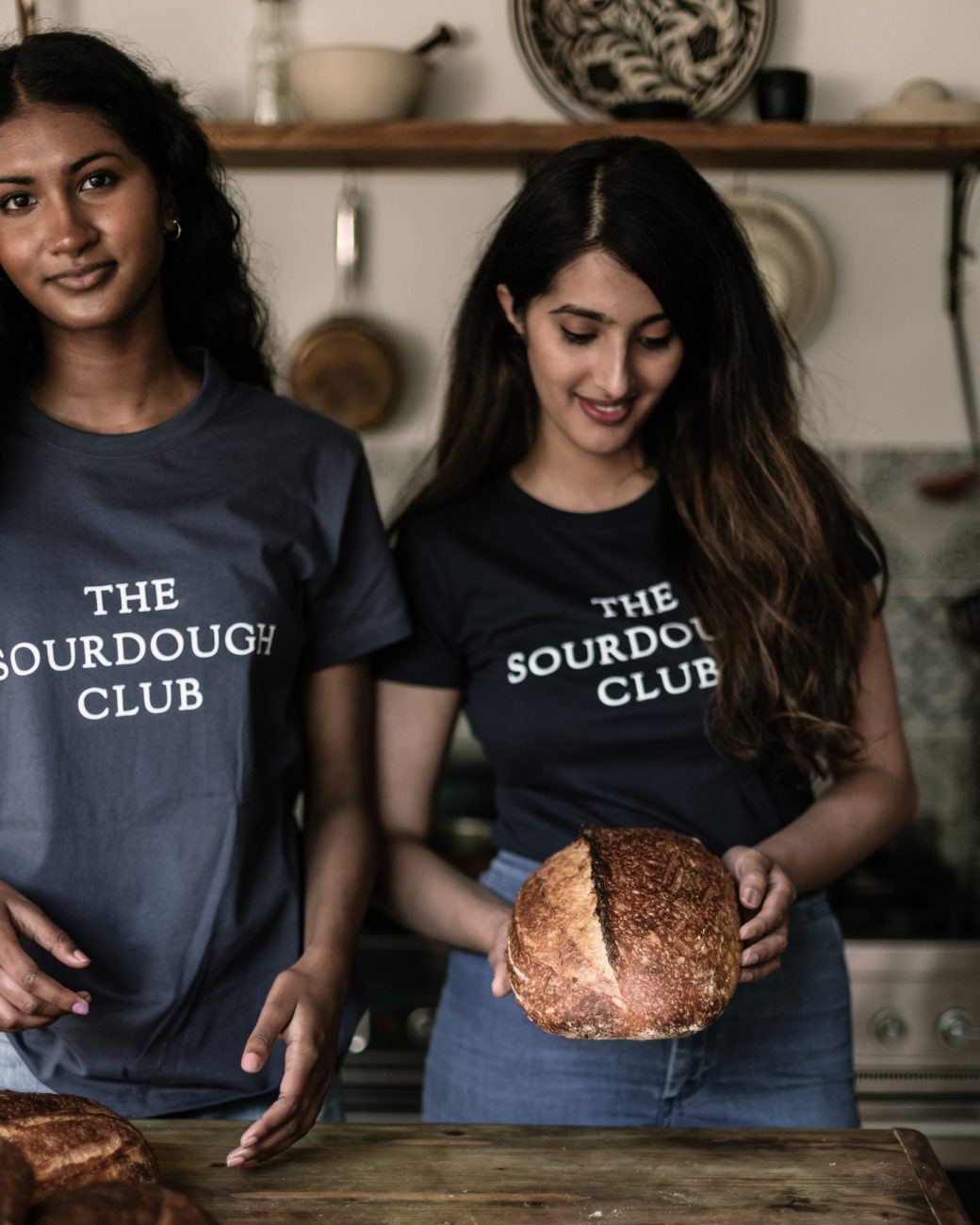 Two students at the sourdough school holding bread