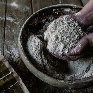 Freshly-milled flour scooped up in a baker's hands ready for use
